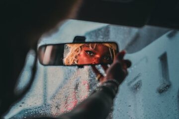 mujer viendo por el retrovisor del auto